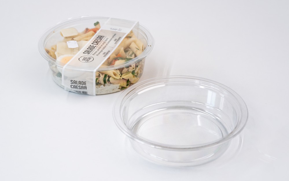 Barquette en plastique transparente munie d’un opercule hermétique, conçue pour conserver la fraîcheur et la présentation soignée d'une salade César, alliant praticité et modernité dans son design.
