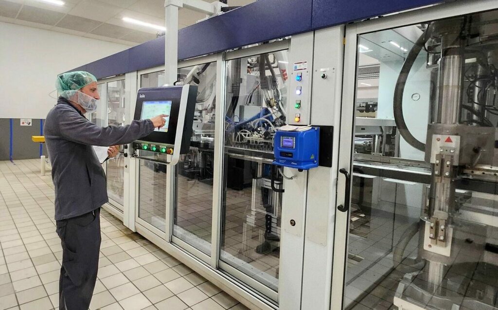 Machine de thermoformage en action, avec un opérateur concentré réglant minutieusement les paramètres sur l'interface de contrôle, illustrant l'importance de la précision technique dans le processus industriel.
