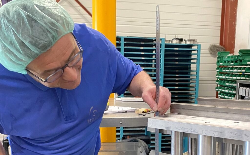 Portrait de Christophe, collaborateur expert en outillage thermoformage, capturé en milieu industriel avec un regard concentré et un uniforme professionnel, symbolisant son rôle clé dans la conception et la maintenance des outils de production.