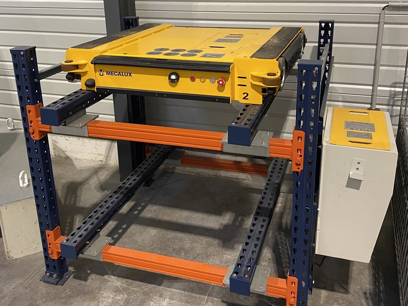 Palette shuttle en action dans un entrepôt moderne, illustrant un système automatisé de transport de palettes. Cet équipement optimise la logistique en facilitant le déplacement rapide et précis des charges dans l'espace de stockage.