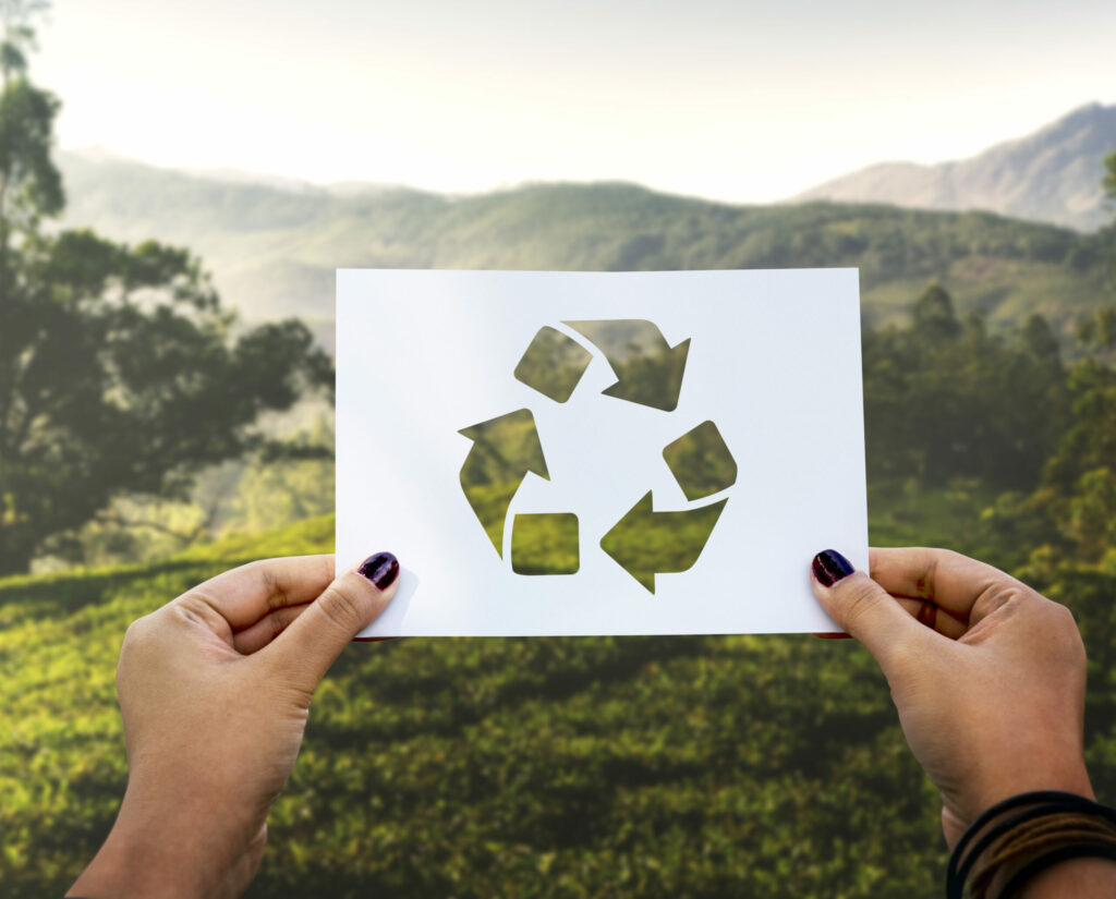 Image illustrant la conservation de l'environnement et l'écologie avec du papier perforé recyclé, représentant un geste symbolique pour sauver la planète